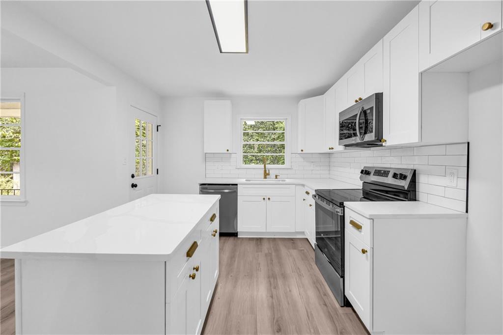 2678 Rainbow Forest Drive Decatur, GA 30034 - Photo 13 of 48 a kitchen with a stove a sink a microwave and wooden floor