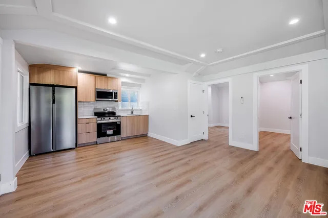 a view of kitchen with stainless steel appliances a refrigerator and wooden floor