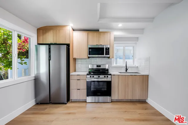 a kitchen with stainless steel appliances a stove a refrigerator and a sink