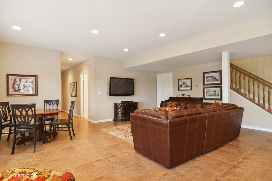 91 Roberts Road Inverness, IL 60067 - Photo 20 of 36 a living room with furniture a dining table and a flat screen tv