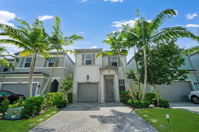 a front view of a house with a yard and potted plants