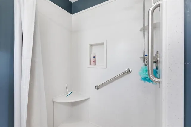 a bedroom with a bed a chandelier and dresser