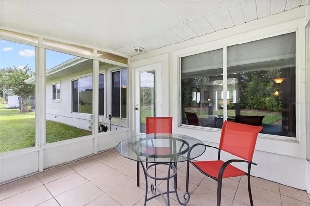 a view of a white house with a big yard and potted plants