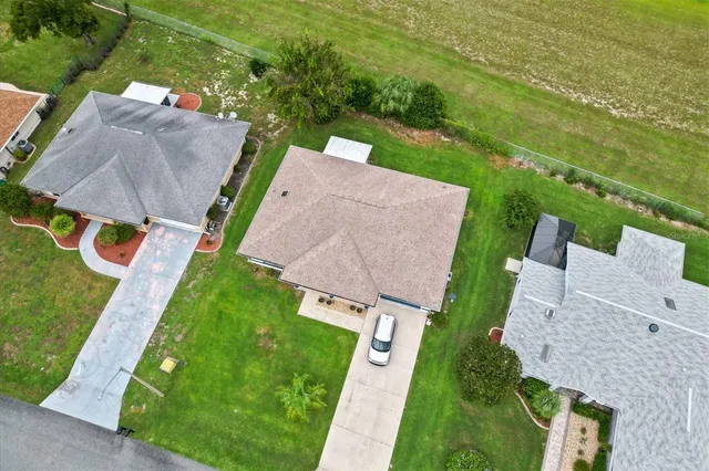 an aerial view of a house with a garden and lake view