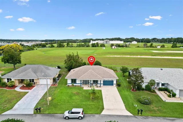 an aerial view of a house with a garden and lake view