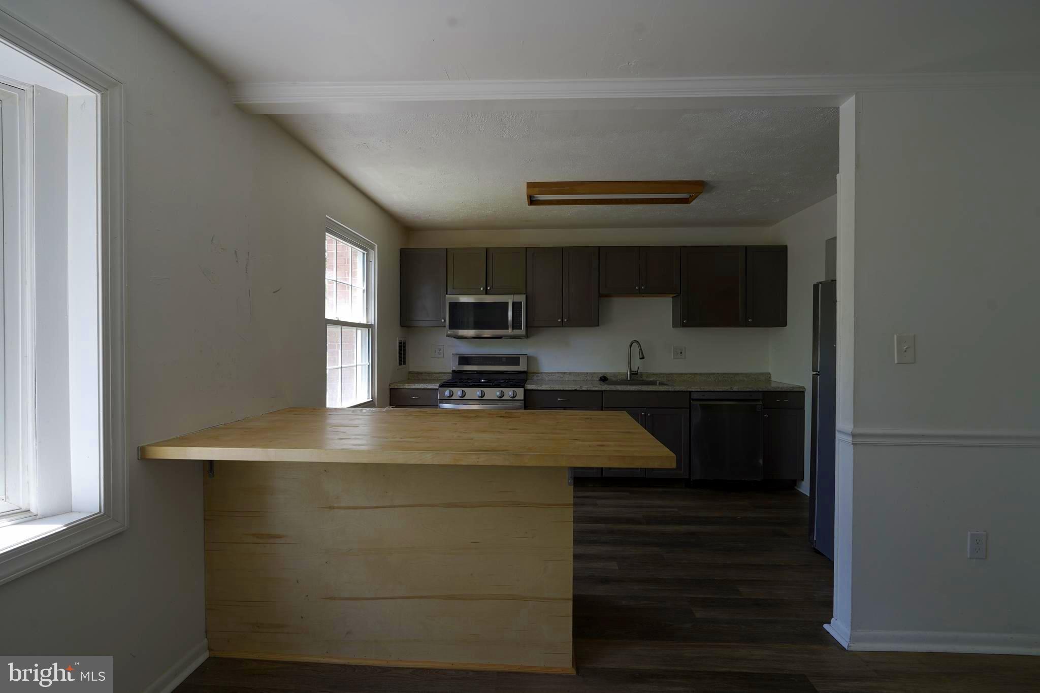 12836 Claxton Drive, Unit 4E Laurel, MD 20708 - Photo 7 of 13 a kitchen with kitchen island a sink stainless steel appliances and cabinets
