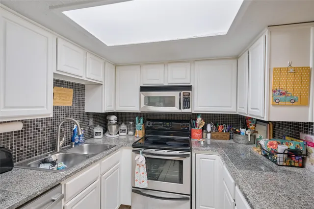 a kitchen with stainless steel appliances granite countertop a sink stove and cabinets