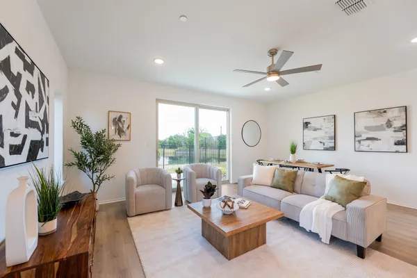 a living room with furniture kitchen and a large window