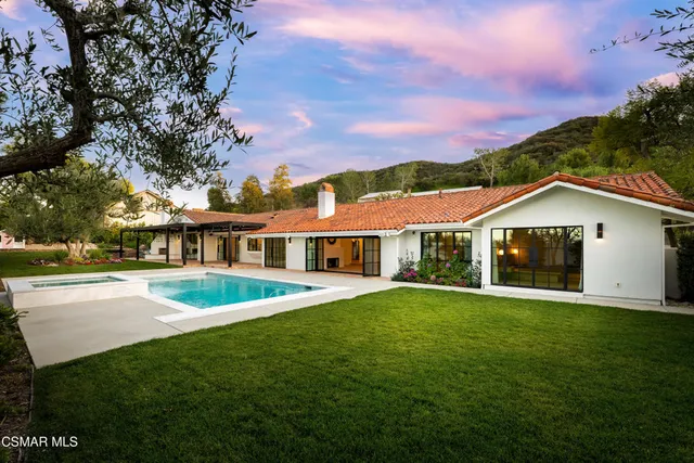 a view of a house with a big yard and large trees