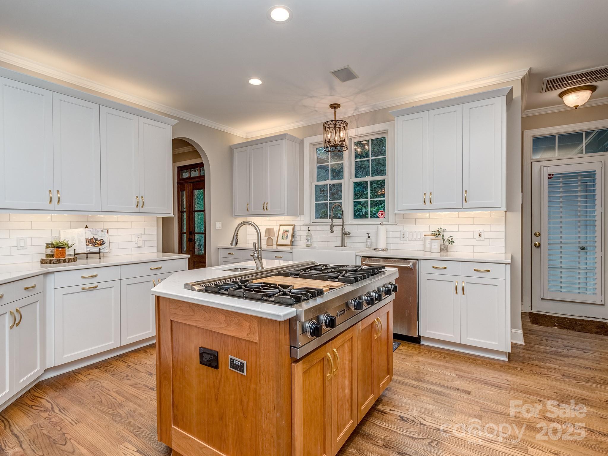 5951 Johnson Road Clover, SC 29710 - Photo 19 of 48 a kitchen with granite countertop stove a sink dishwasher and white cabinets with wooden floor