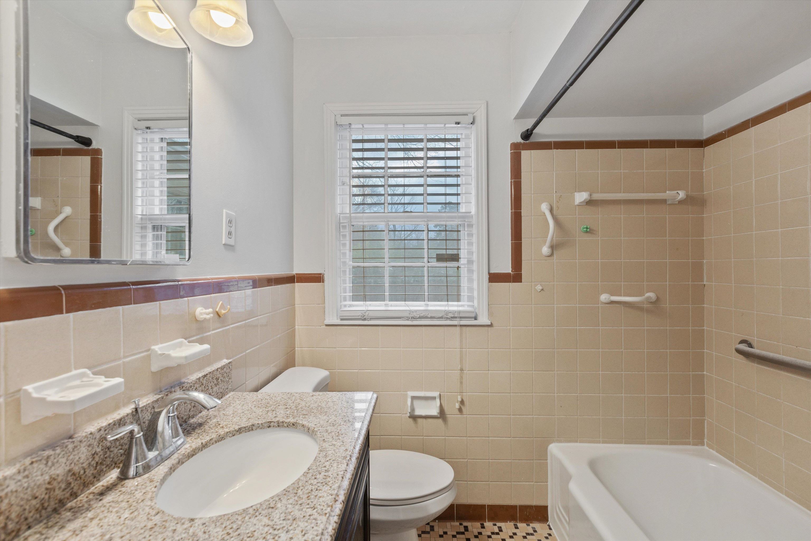5555 Barfield Road Memphis, TN 38120 - Photo 19 of 23 a bathroom with a granite countertop toilet a sink and a mirror