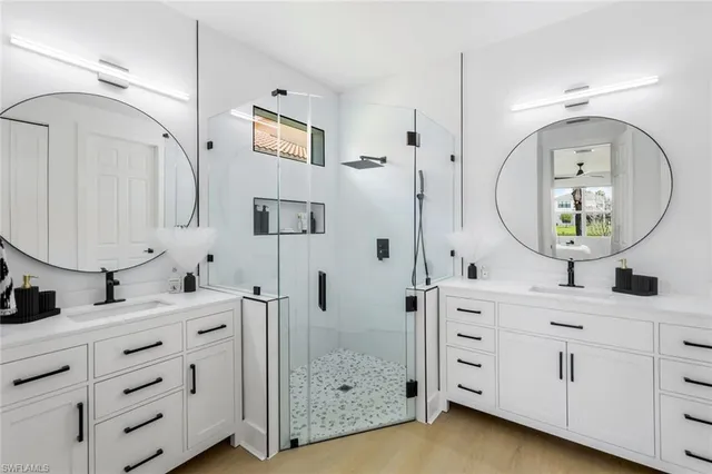 a bathroom with a double vanity sink mirror and bathtub