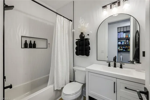 a bathroom with a sink a toilet a mirror and shower