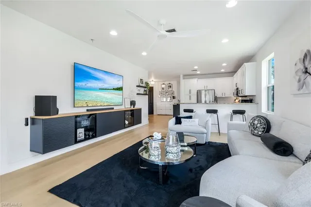 a living room with furniture kitchen view and a flat screen tv