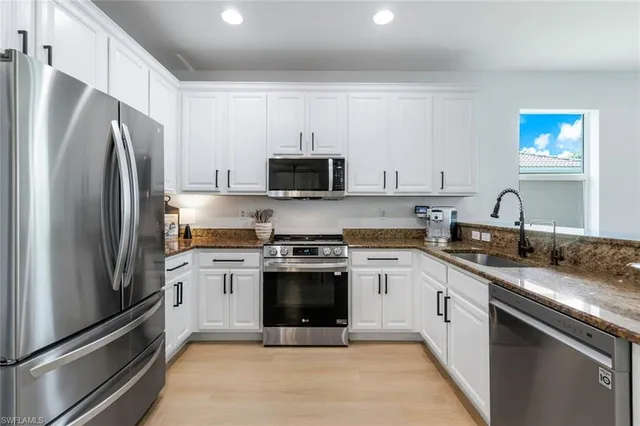 a kitchen with stainless steel appliances granite countertop a stove a refrigerator and a sink