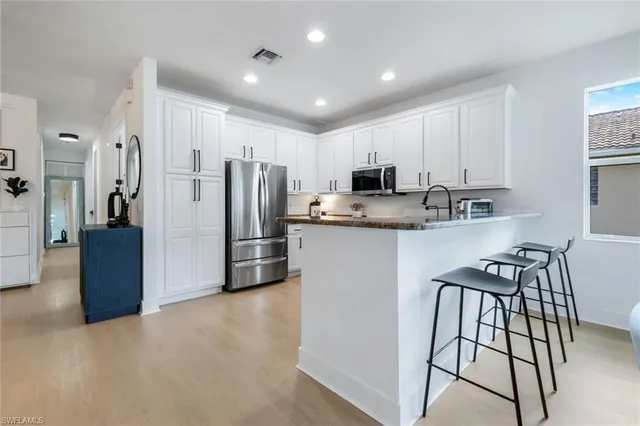 a kitchen with kitchen island a counter top space cabinets and stainless steel appliances