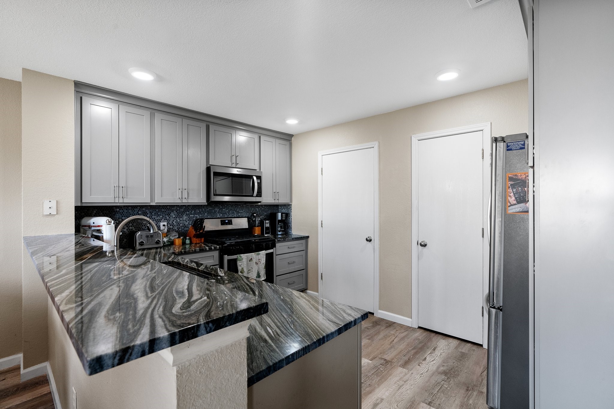 191 Jack Rabbit Lane Buda, TX 78610 - Photo 1 of 1 Recessed lighting reflects in the kitchen and further enhances the luxurious ambiance.