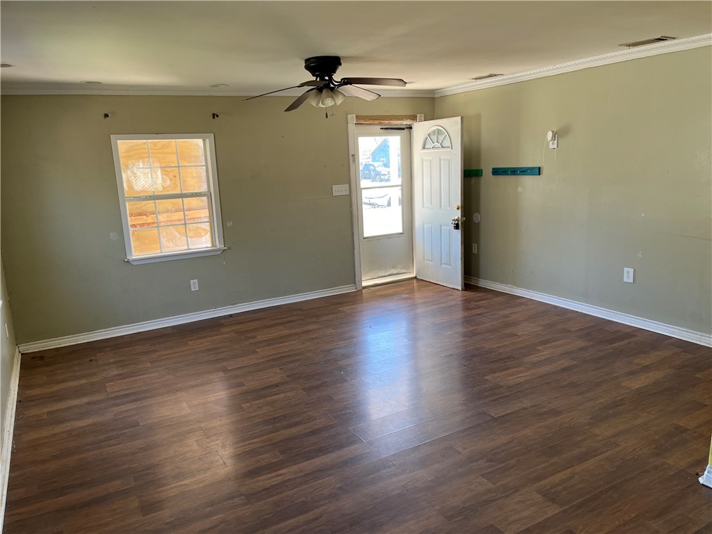 123 Burnet Street Port Lavaca, TX 77979 - Photo 2 of 9 a view of an empty room with a window and wooden floor