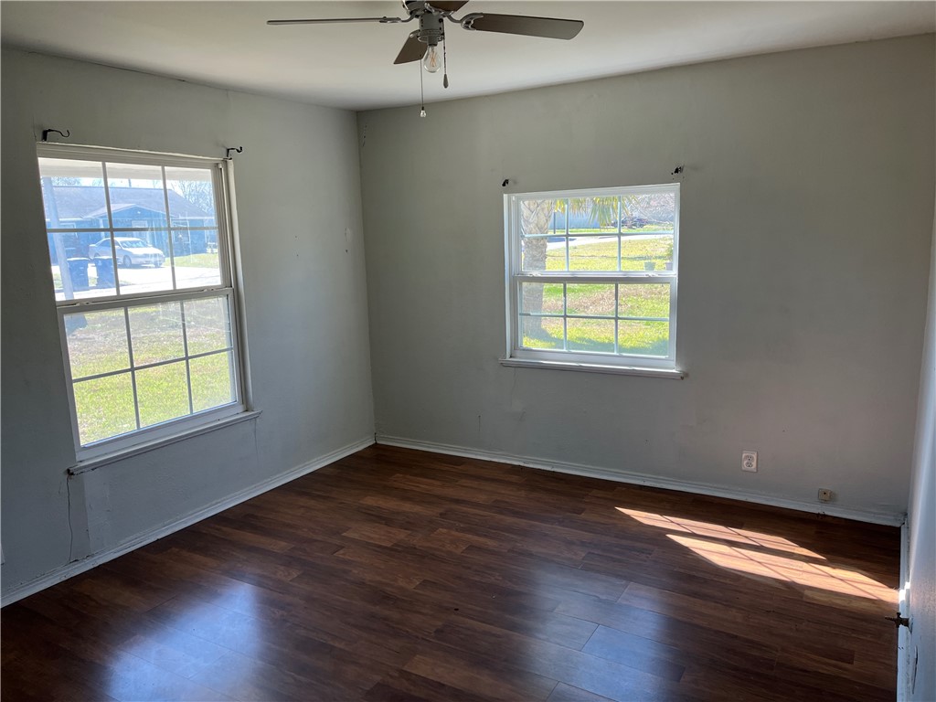 123 Burnet Street Port Lavaca, TX 77979 - Photo 5 of 9 a view of an empty room with wooden floor and a window