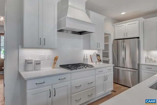 a kitchen with appliances a refrigerator and a stove top oven
