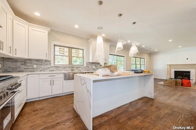 a kitchen with granite countertop a sink appliances cabinets and a counter top space