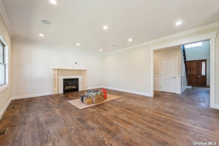 608 Meadowbrook Road North Merrick, NY 11566 - Photo 16 of 36 an empty room with wooden floor and a fireplace