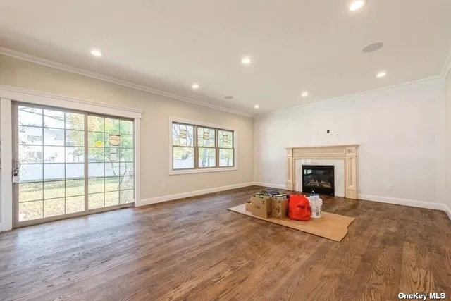 a view of empty room with fireplace and wooden floor