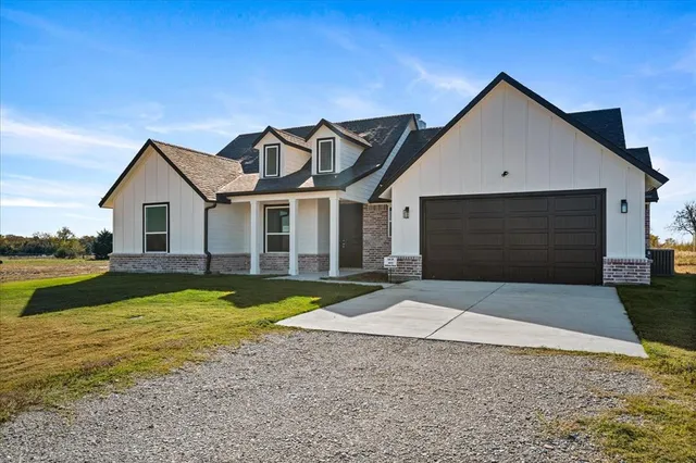 a front view of a house with yard and lake view