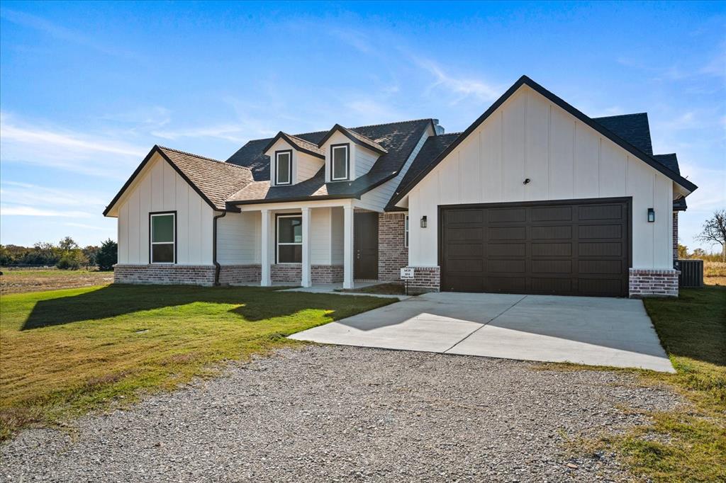 a front view of a house with yard and lake view