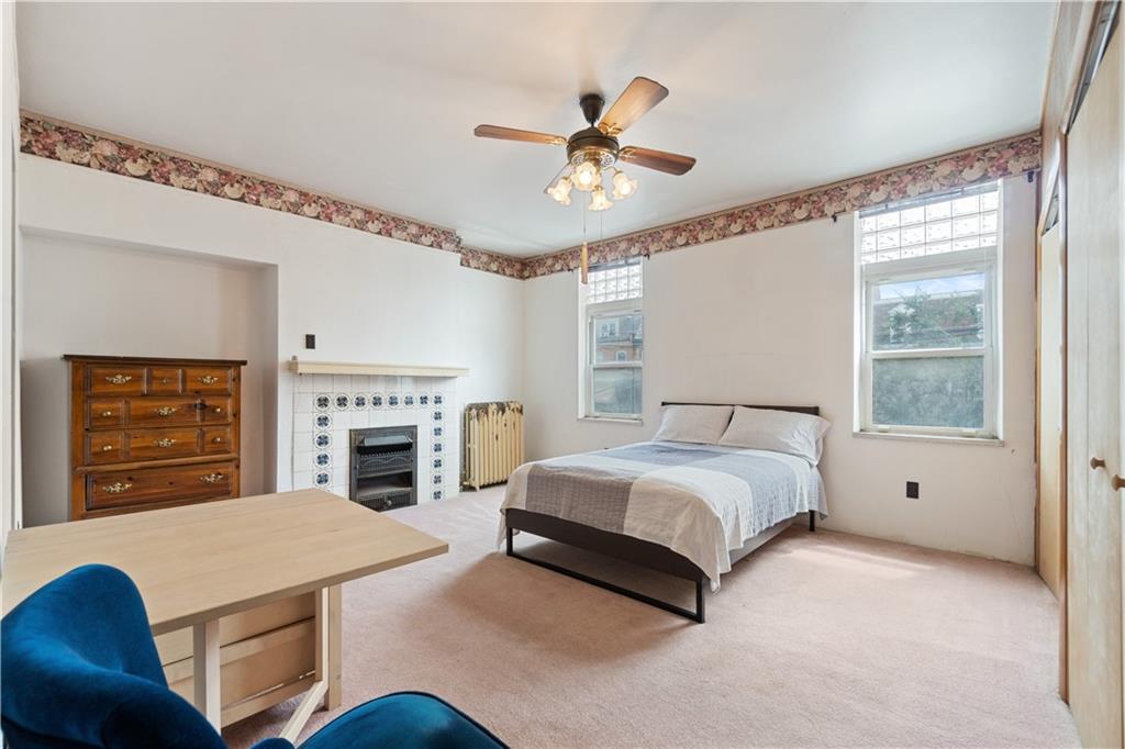 3407 Ward Street Pittsburgh, PA 15213 - Photo 15 of 39 a spacious bedroom with a bed and a chandelier