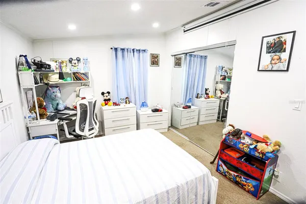 a large bed sitting in a bedroom next to a cabinet