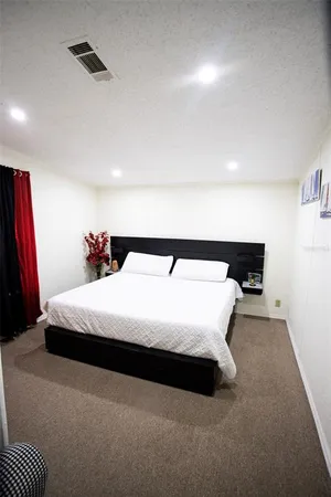 a spacious bedroom with a bed and a flat screen tv