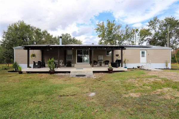 a view of a house with backyard and sitting area