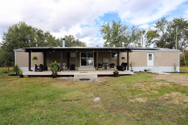 a view of a house with backyard and sitting area