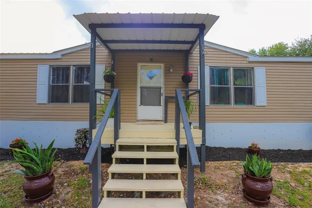 a front view of a house with potted plants
