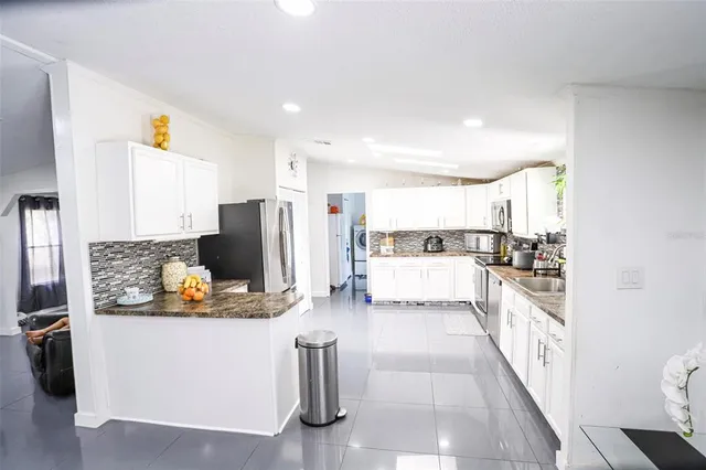 a kitchen with stainless steel appliances granite countertop a refrigerator and a stove
