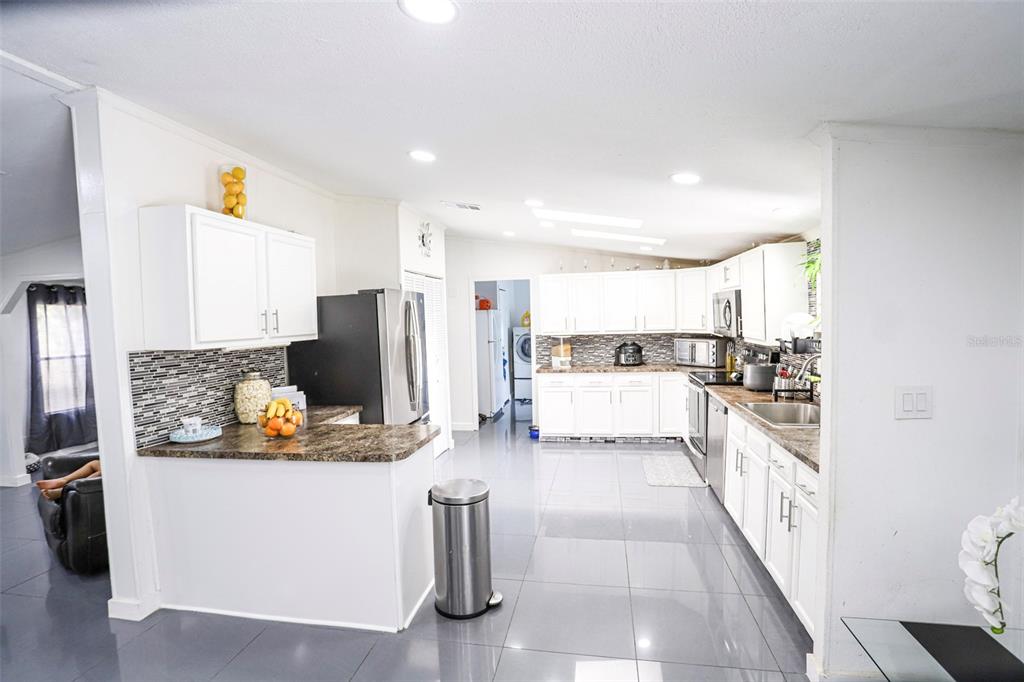 41 Ferguson Lane Frostproof, FL 33843 - Photo 5 of 33 a kitchen with stainless steel appliances granite countertop a refrigerator and a stove