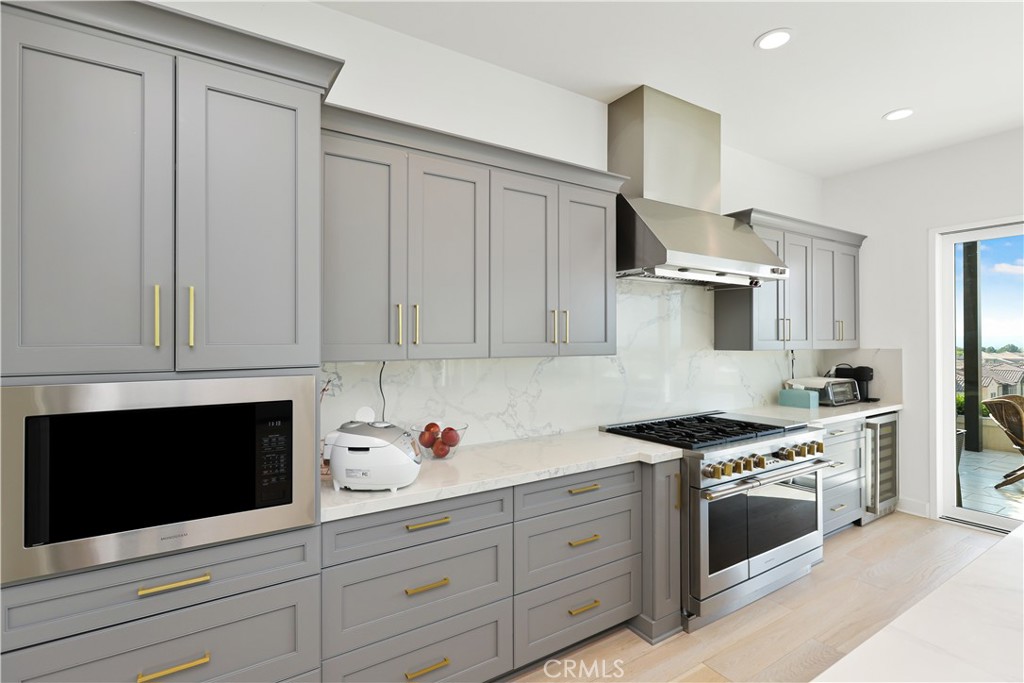 108 Salt Spring Irvine, CA 92602 - Photo 12 of 75 a kitchen with stainless steel appliances granite countertop a stove a microwave and white cabinets