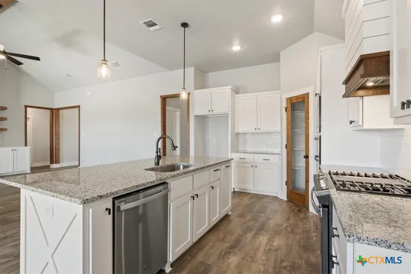 a kitchen with stainless steel appliances granite countertop a sink refrigerator and cabinets