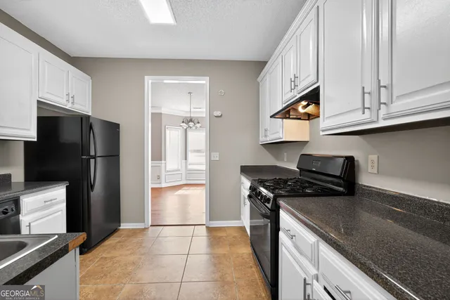 a kitchen with stainless steel appliances granite countertop a refrigerator a stove and a sink