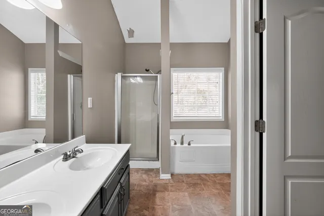 a en suite bathroom with a granite countertop sink and a mirror