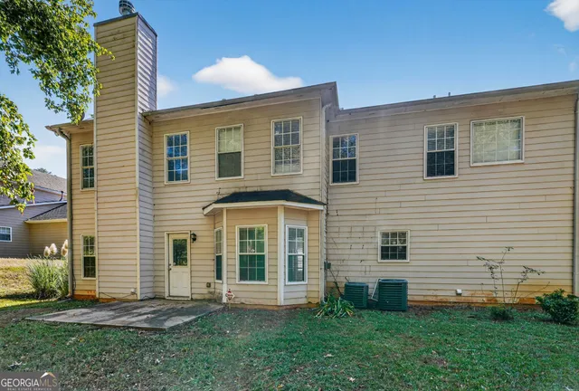 a view of a backyard with plants and large tree