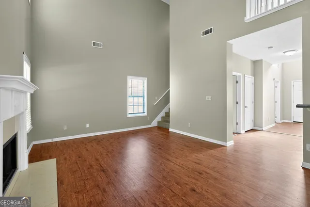 a view of a livingroom with wooden floor and a fireplace