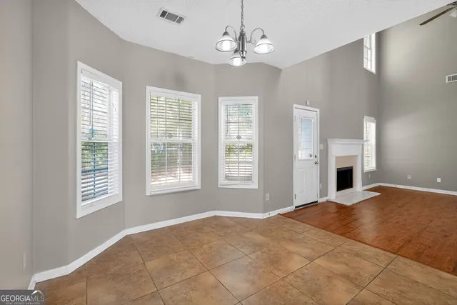 a view of a livingroom with a chandelier fan and windows