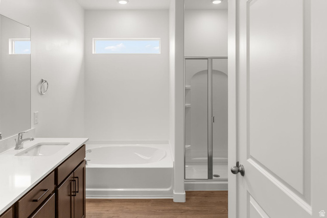 1417 West 2350th South, Unit 14 Perry, UT 84302 - Photo 6 of 19 Modern bathroom featuring a soaking tub, glass-enclosed shower, wood-finish flooring, dark wood vanity with white countertop, and contemporary rectangular sink