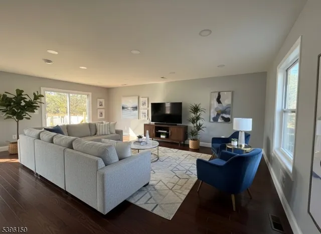 a living room with furniture a flat screen tv and a window