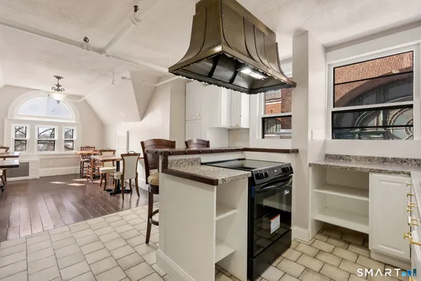 a kitchen with stainless steel appliances a stove a table and chairs