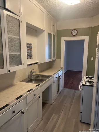 a kitchen with granite countertop a stove and a sink