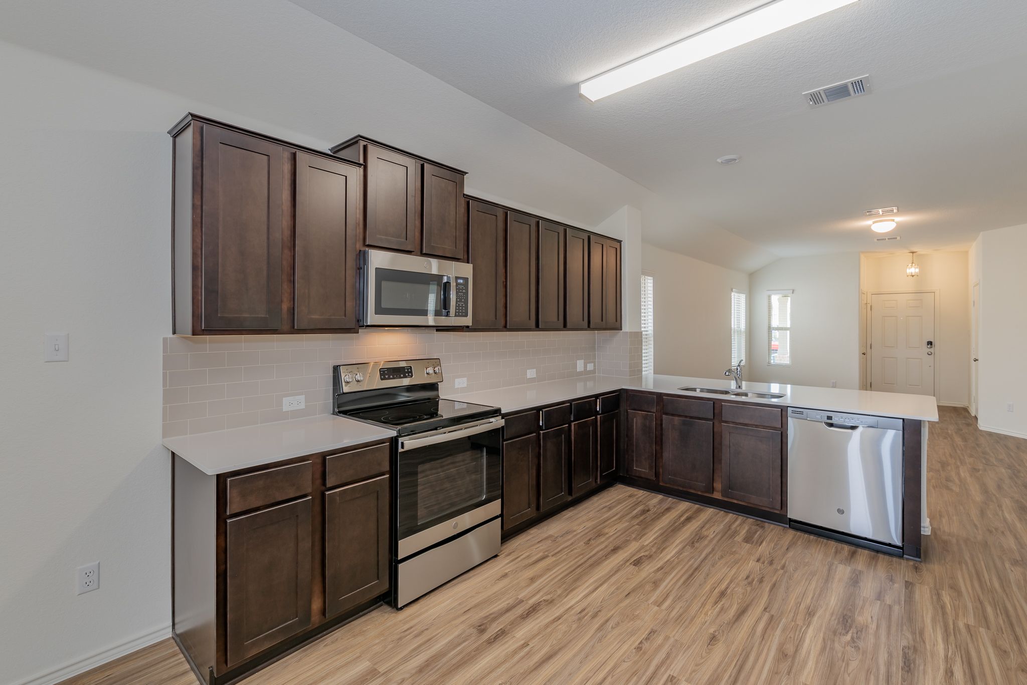 509 Greatest Gift Way Jarrell, TX 76537 - Photo 11 of 28 a kitchen with stainless steel appliances granite countertop wooden cabinets a stove top oven a sink and dishwasher
