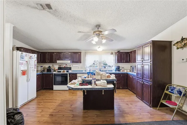 a living room with stainless steel appliances kitchen island granite countertop furniture a refrigerator a sink and a stove